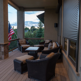 A balcony with wicker furniture and an american flag