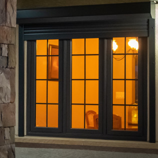 A window with a black frame is lit up at night