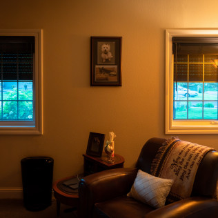 A living room with a couch and two windows