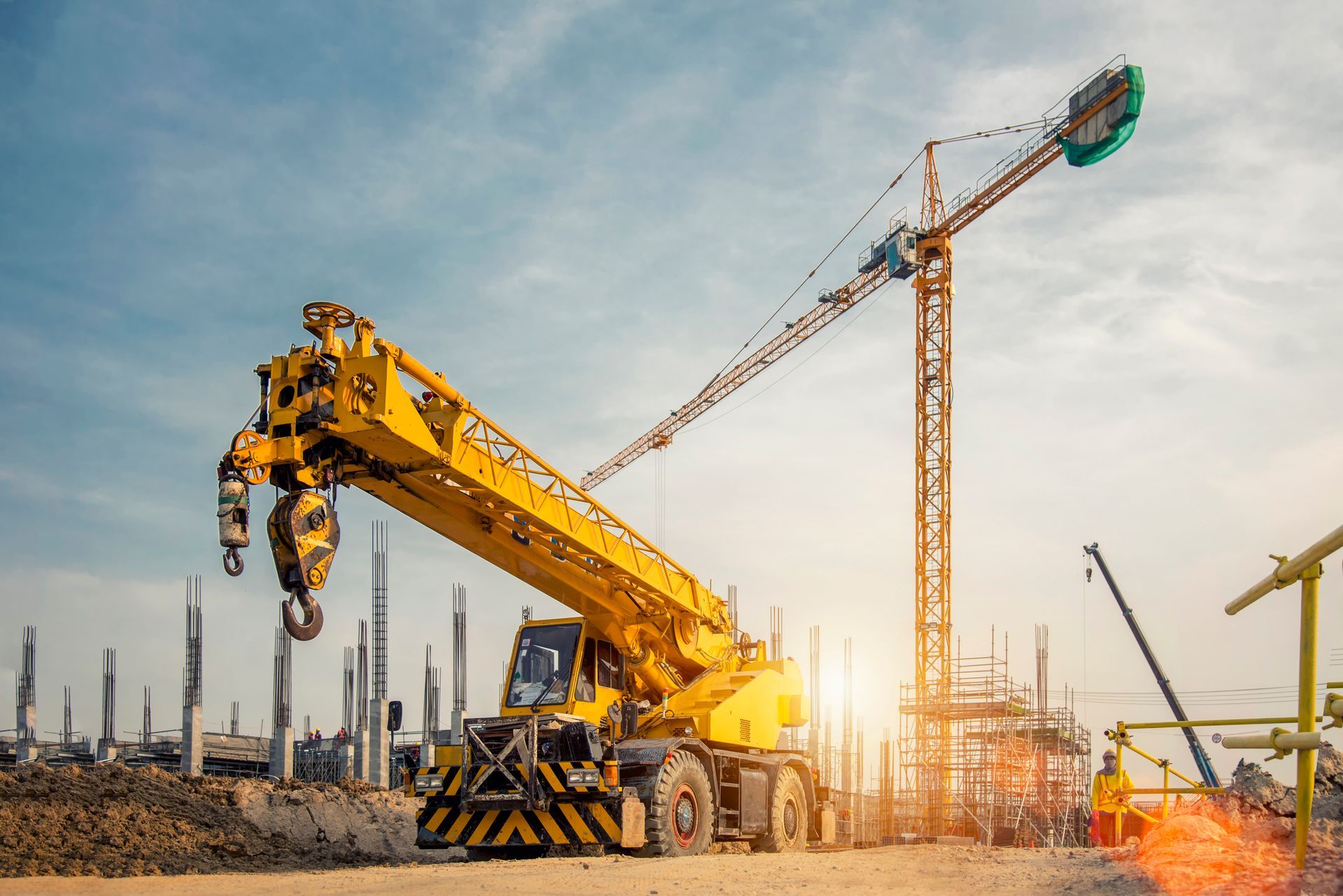 Una gru gialla è seduta in cima a un cantiere edile.
