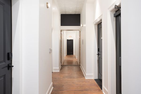 White hallway with black doors.