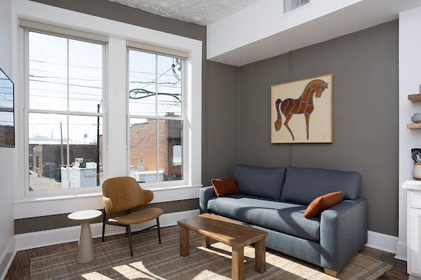 Living area with sofa and chair. Horse painting on the wall.