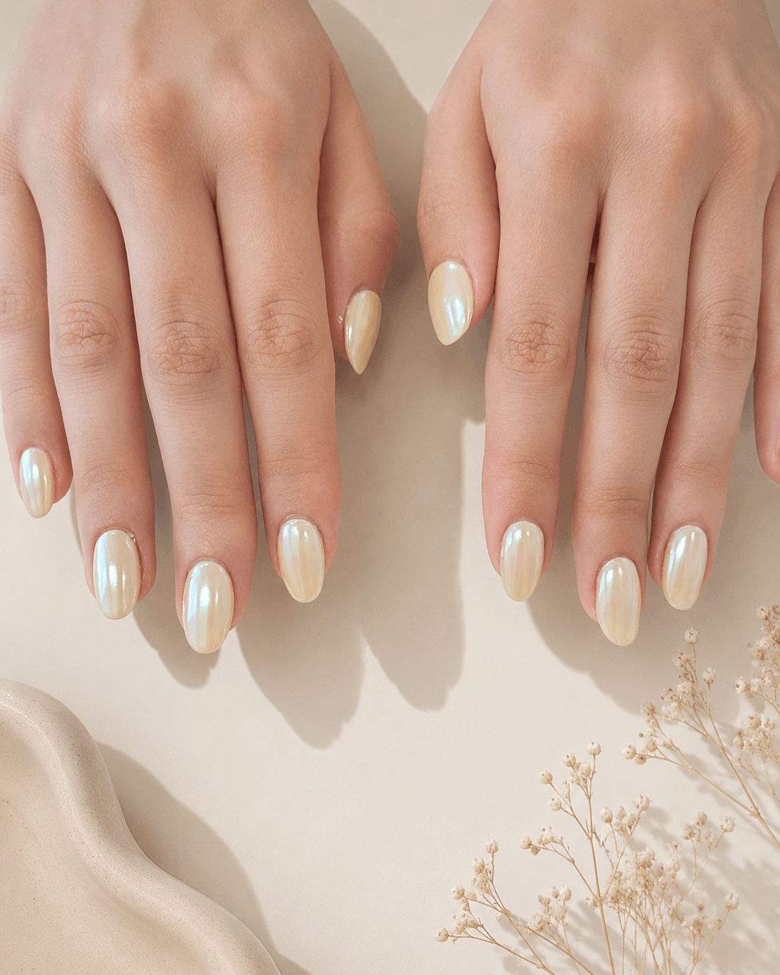 Two hands with glossy ivory nails on a soft beige background