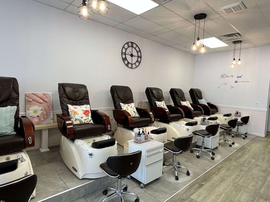 Pedicure salon with rows of massage chairs, foot baths, and bright overhead lights