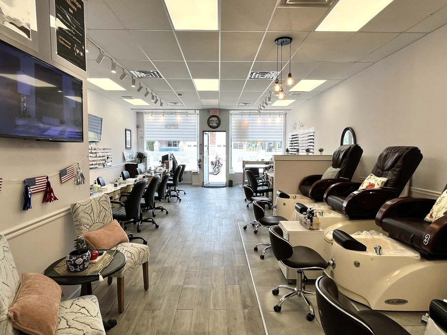 Tattoo studio interior with chairs, workstations, and large tattooing chairs along the right wall
