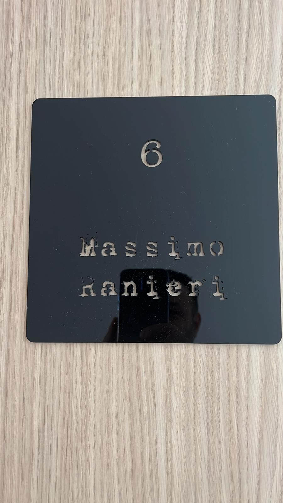 Su una porta di legno c'è un cartello nero con il numero 6.
