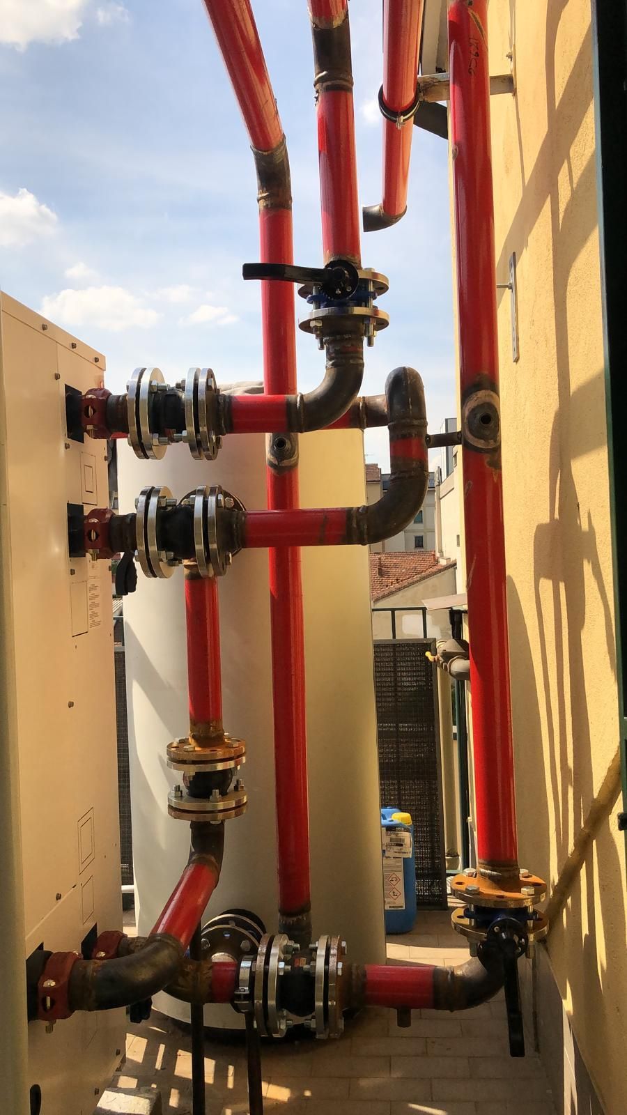 Un gruppo di tubi rossi sono collegati a un muro.