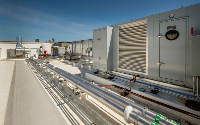 The roof of a building with a lot of pipes and boxes on it.