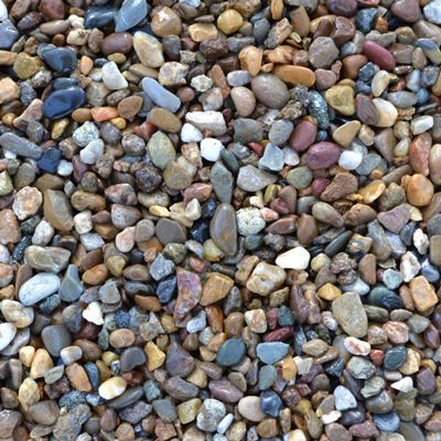 Close-up of a pile of mixed-color river rocks. Browns, grays, and blues are visible.
