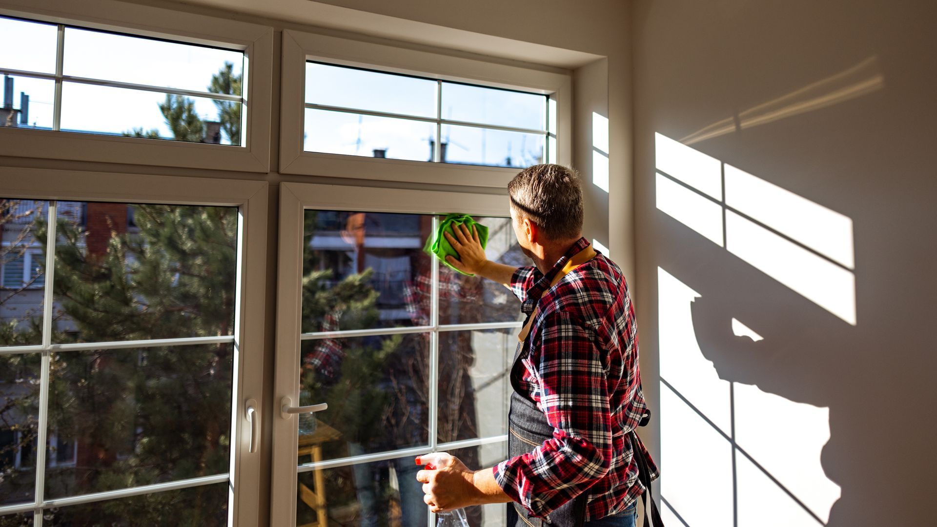 A customer is cleaning his windows after getting a window tinting service.