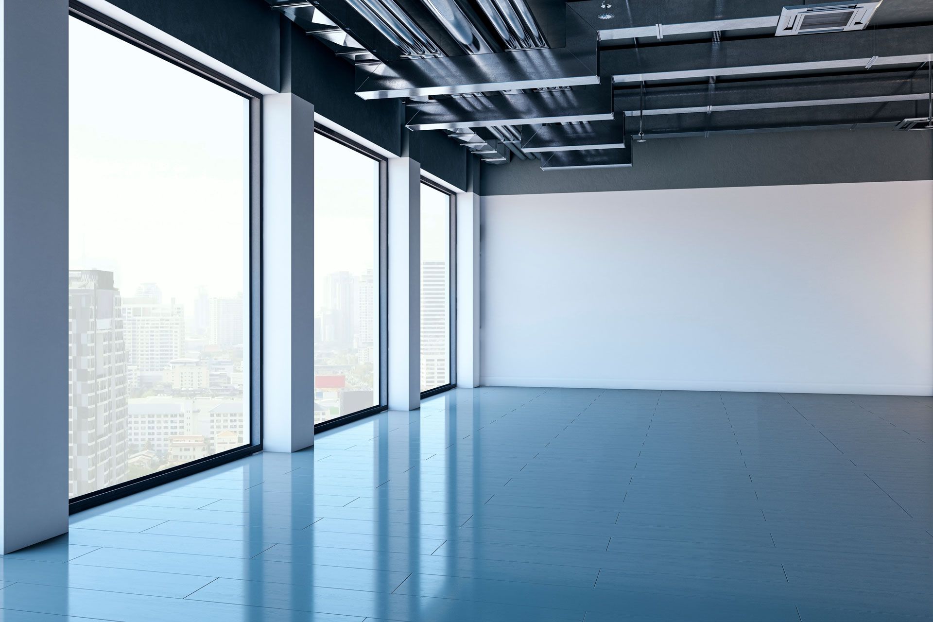 Empty modern office with large windows, exposed ceiling, and blue floor