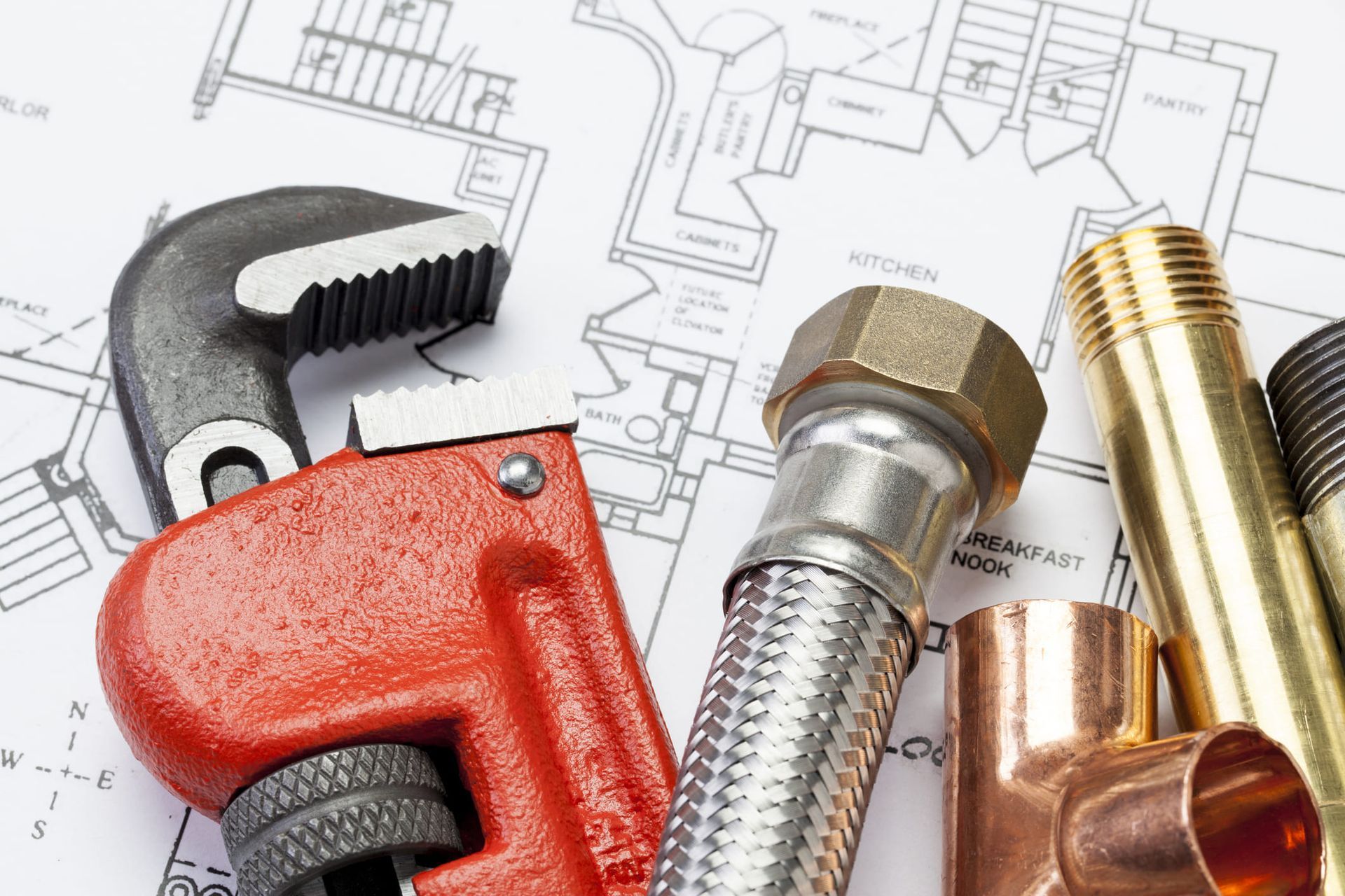 A man and woman are shaking hands with a plumber in a living room.