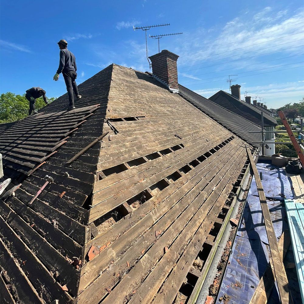 A man is standing on top of a wooden roof.