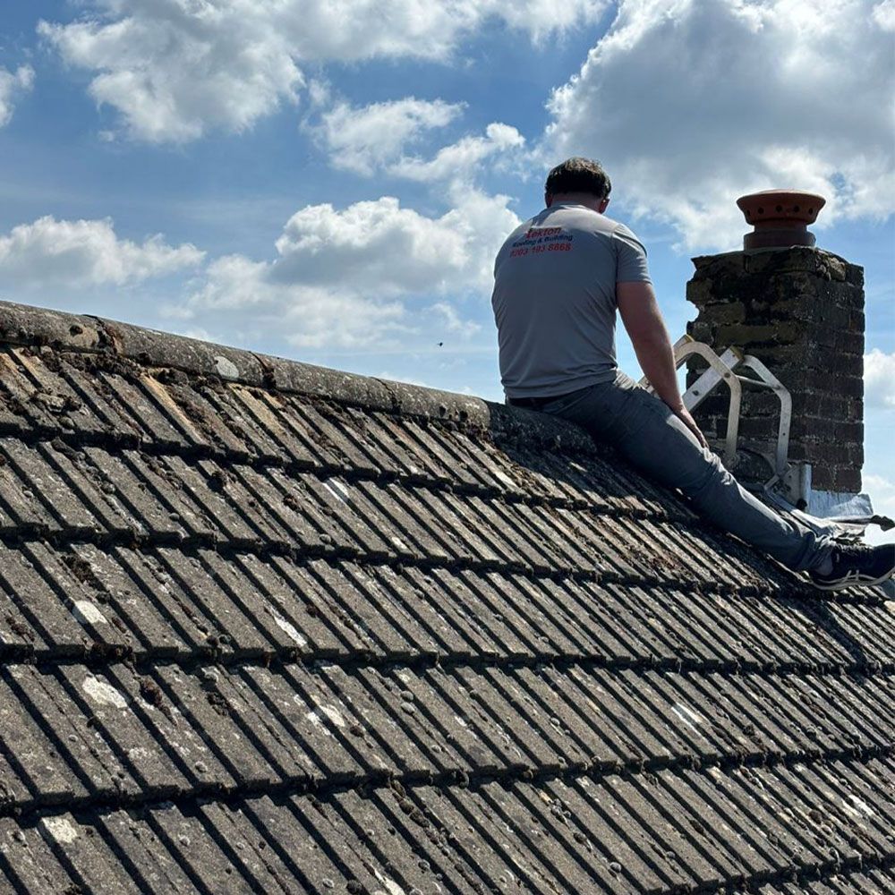 A man is sitting on the roof of a building