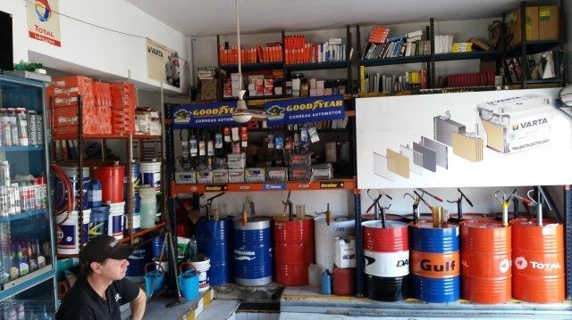 Una pequeña ferretería con estantes llenos de latas de pintura