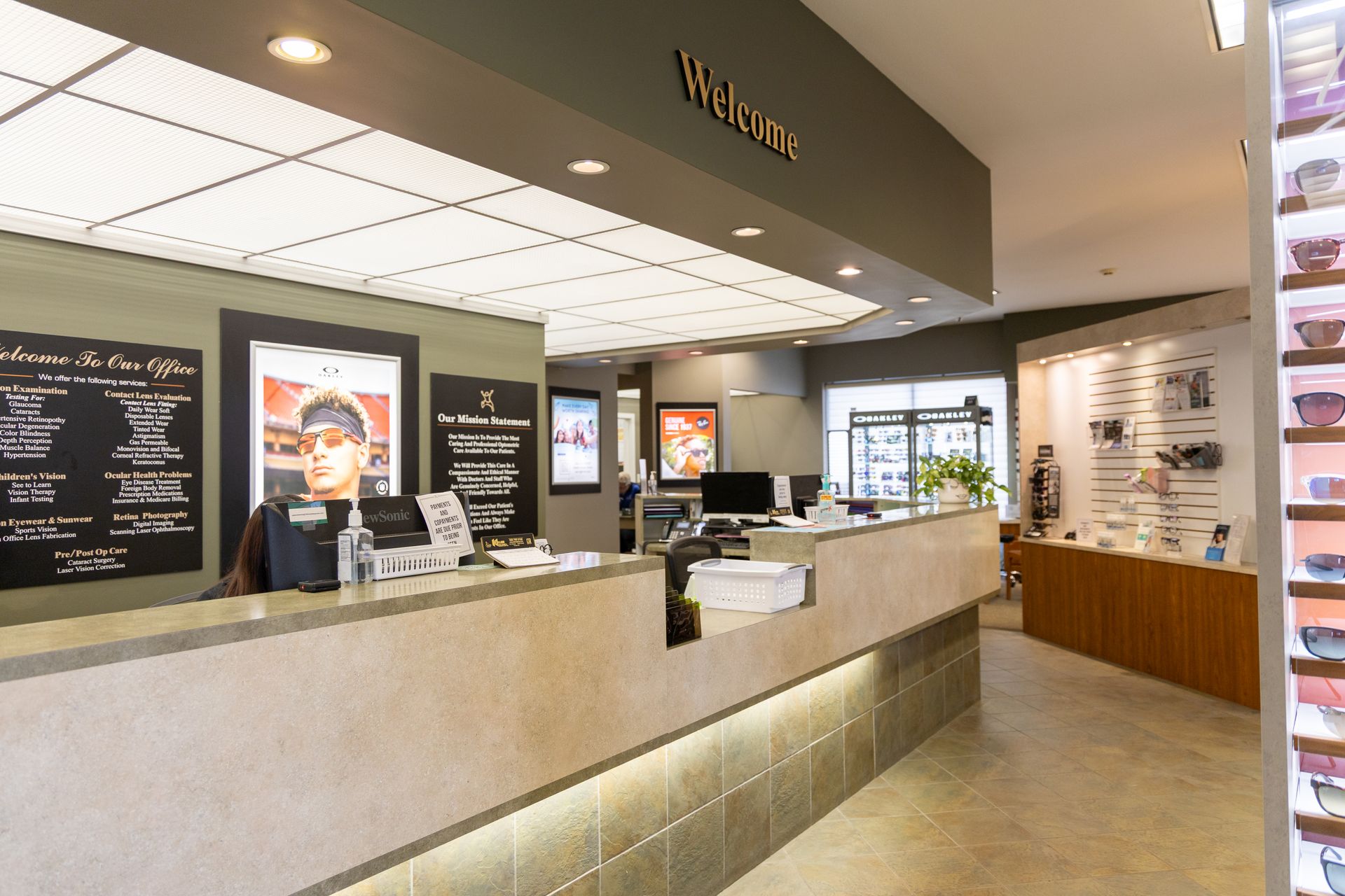 Modern cafe counter with menu boards, dessert displays, and a light stone service area