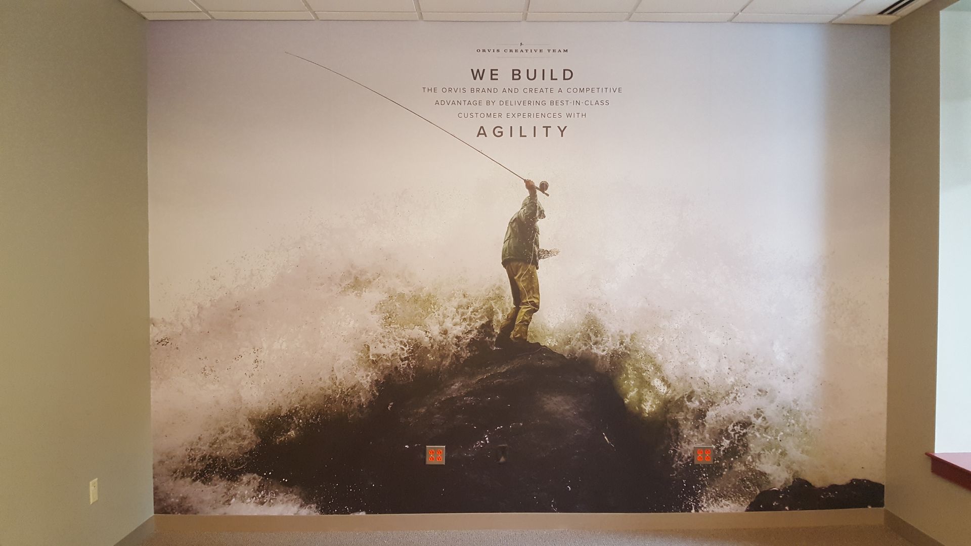 Mural of a lone figure on a dirt mound against a pale wall, with a soft cloudy, earthy background.