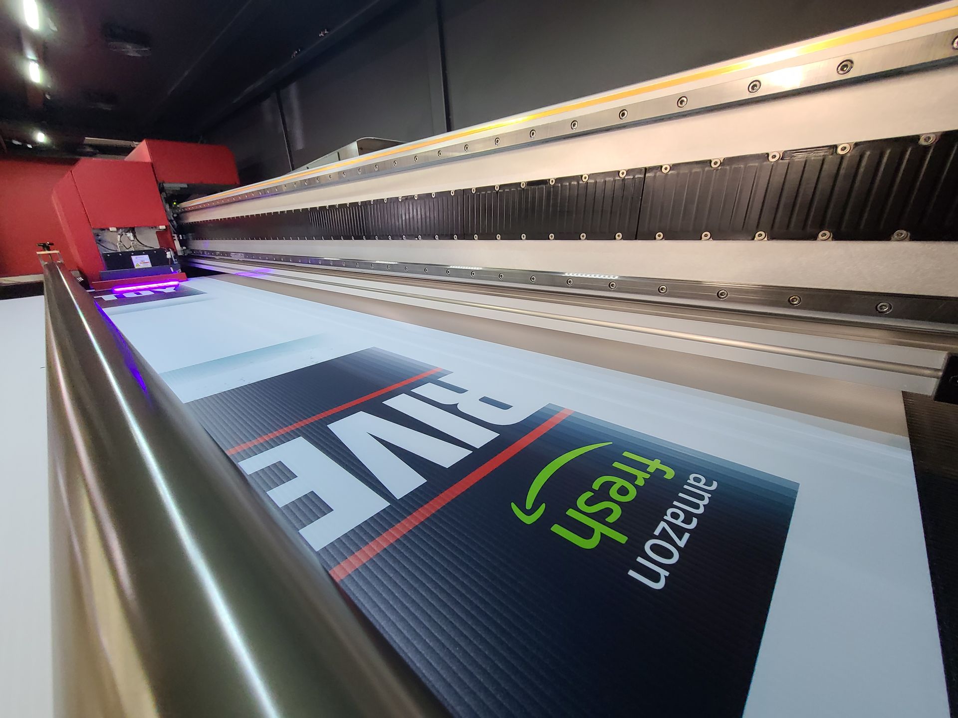 Large-format printer printing a sign with “LIVE” and “USA” on a dark banner