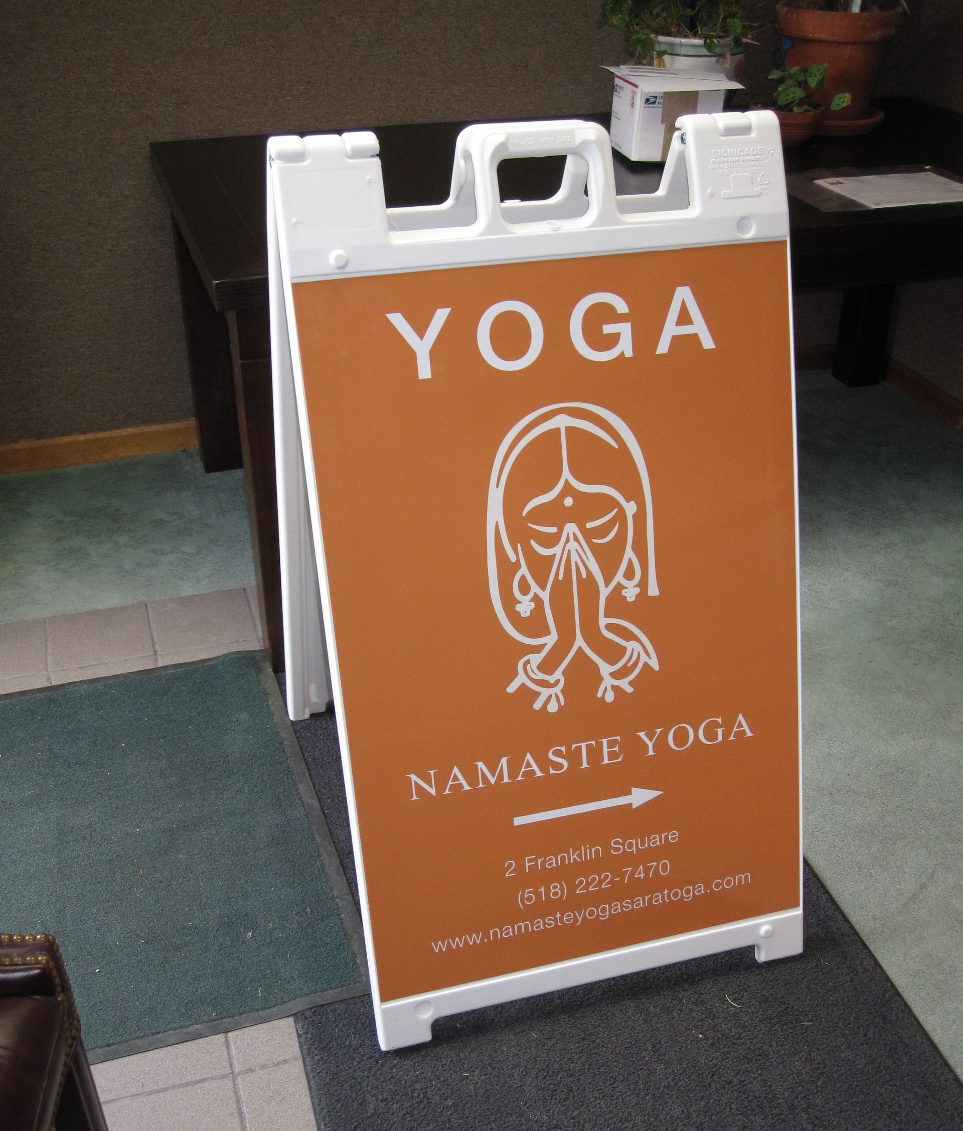White A-frame sign with orange background;