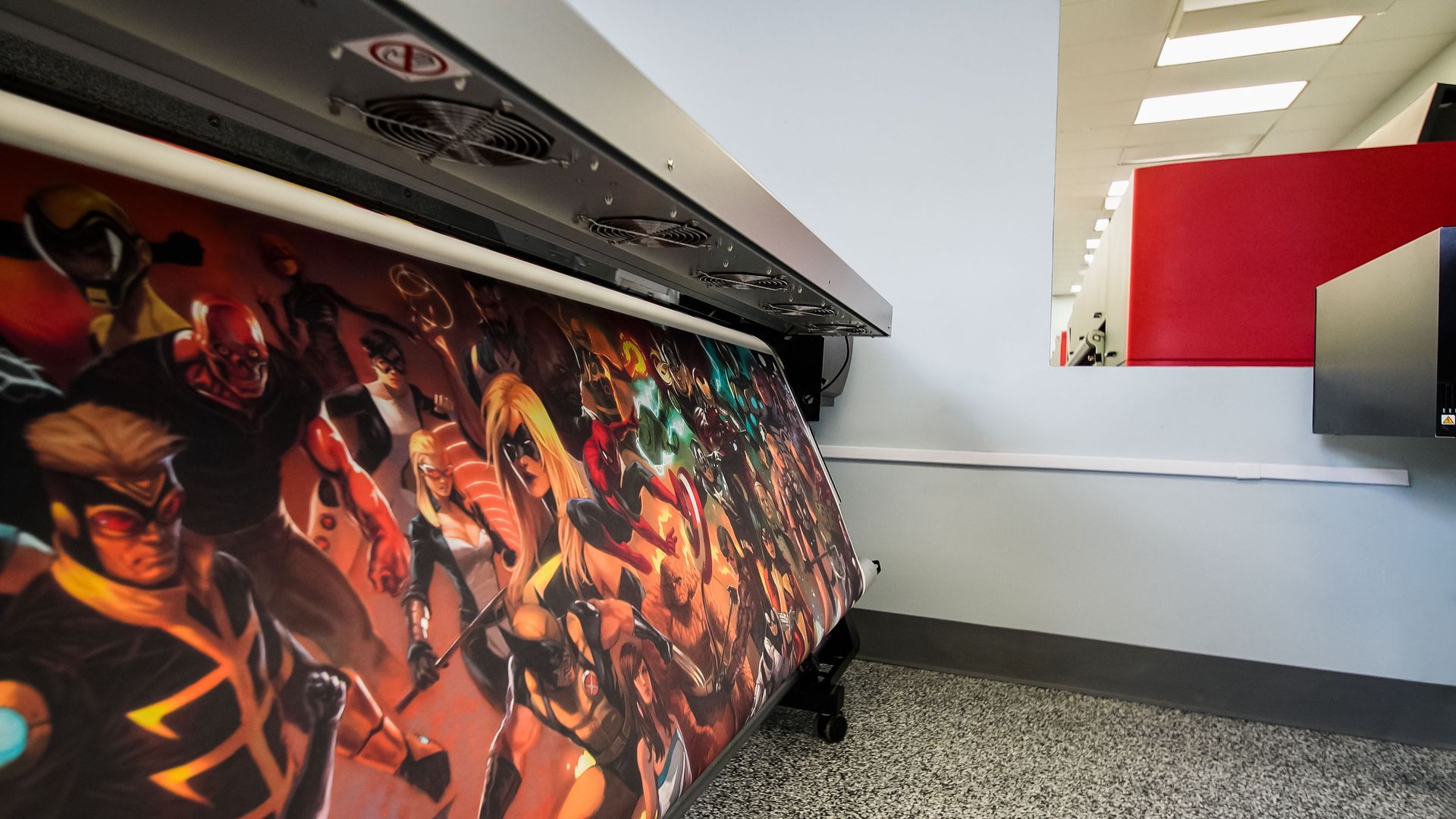 Large format printer printing a colorful comic book art banner.