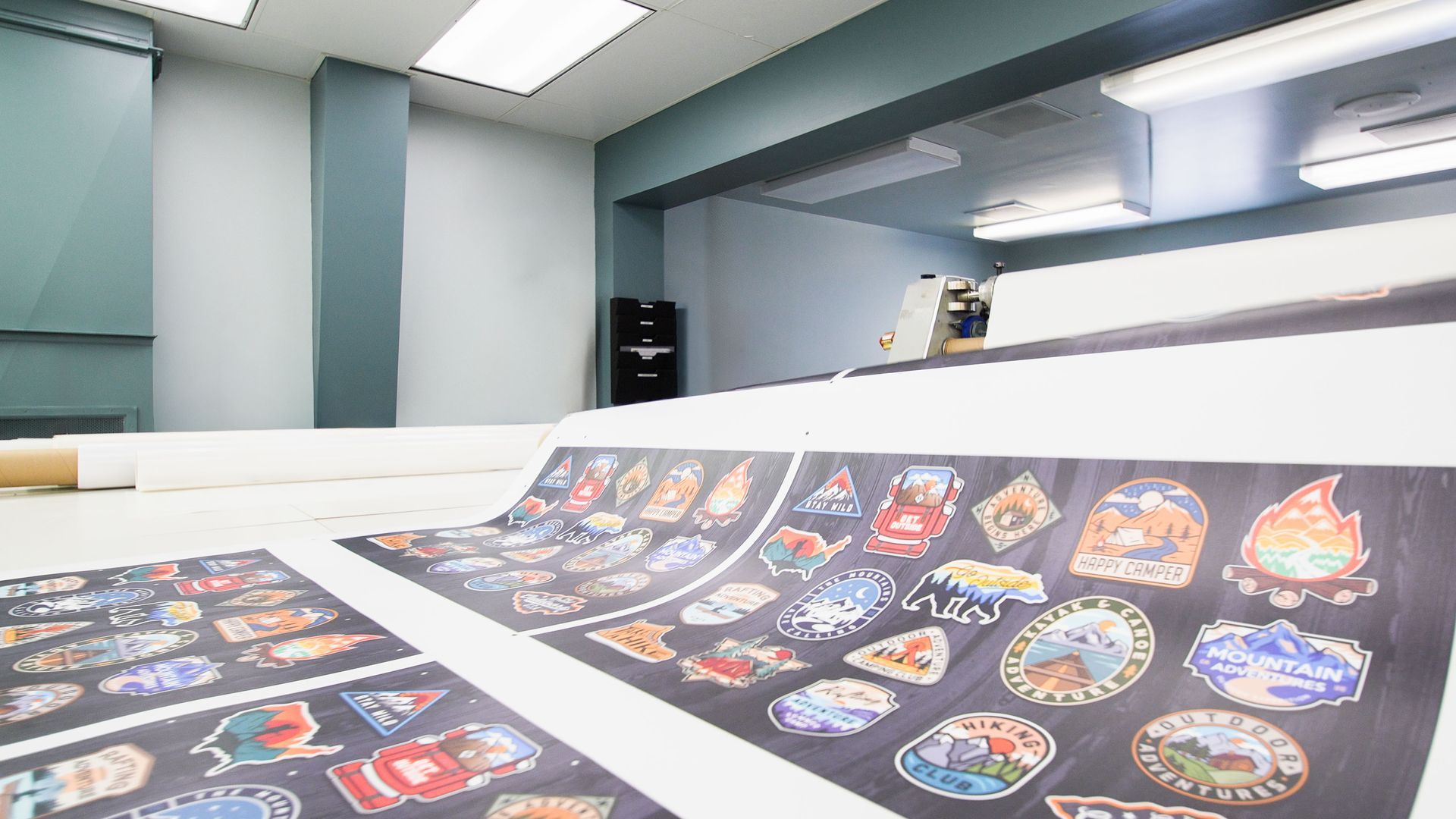 Printed food menu sheets laid out on a counter in a bright modern room.