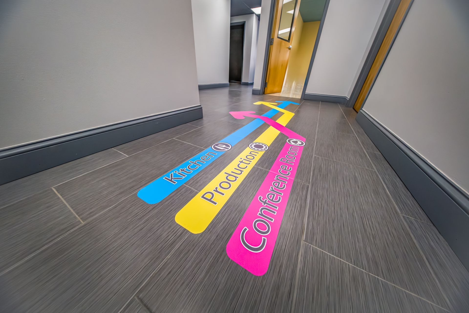 Hallway floor with bright colored directional arrows labeled “Procurement” and “Contracts.”