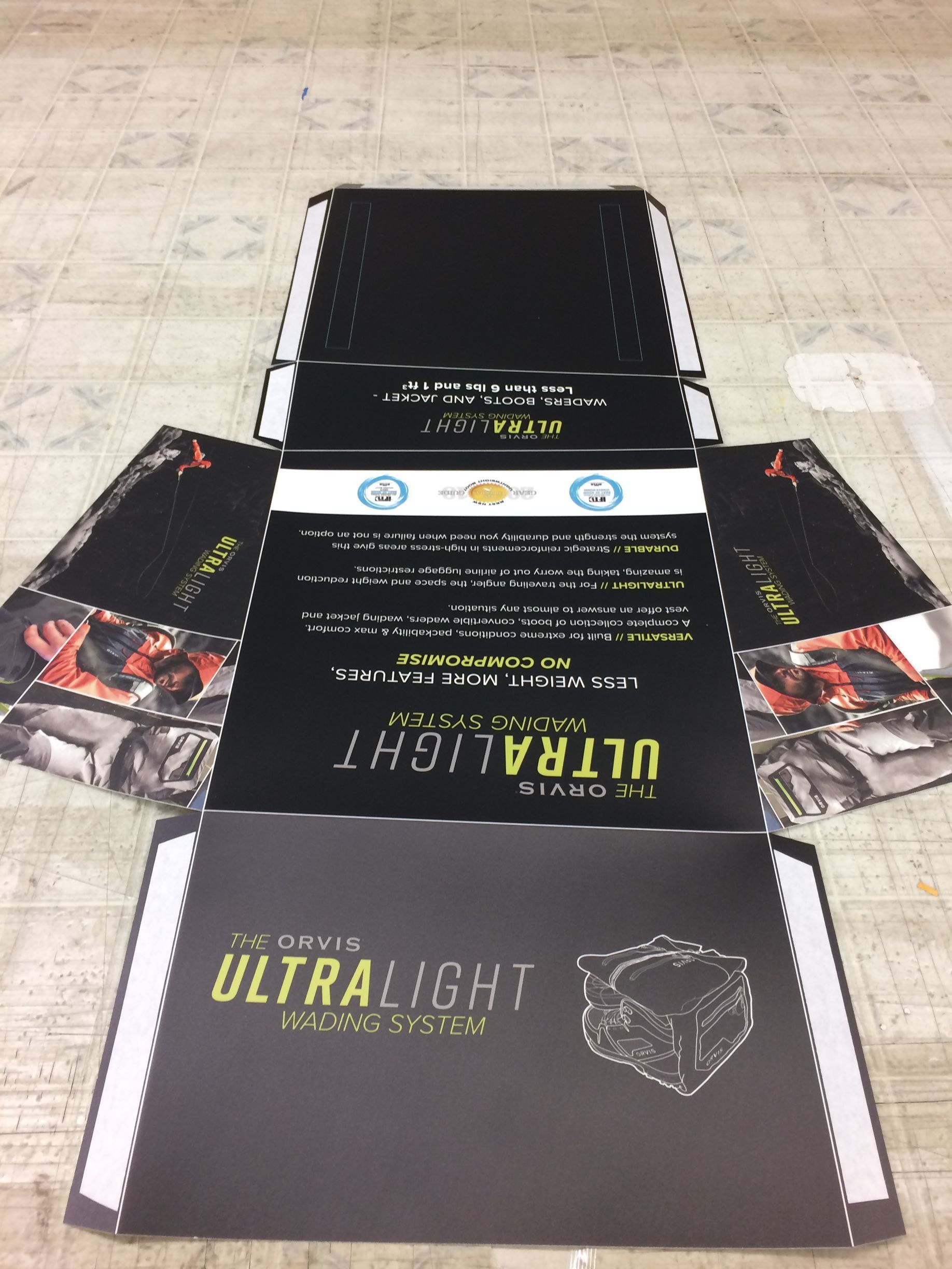 Open black cardboard box laid flat on a table, with printed Ultralight packaging and side flaps visible