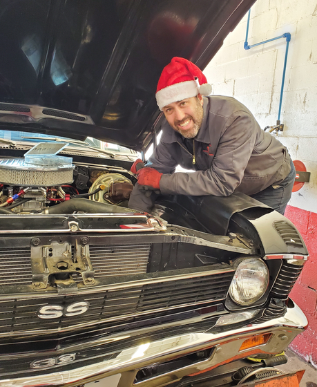 Man In Santa Hat And Red Gloves Leaning Over The Hood Of A 1969 Chevrolet Nova SS | Chapmans Front End & Brakes