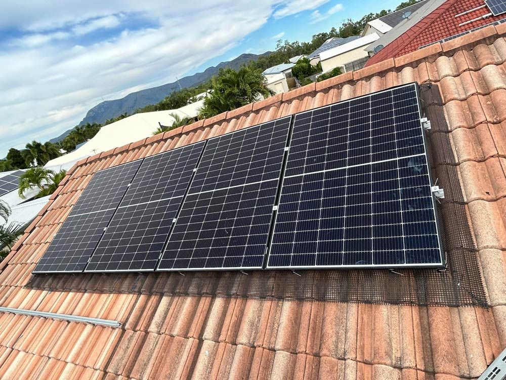 Solar Panels Mounted on a Red-tiled Roof Under a Blue Sky — Central Solar Services in Garbutt, QLD