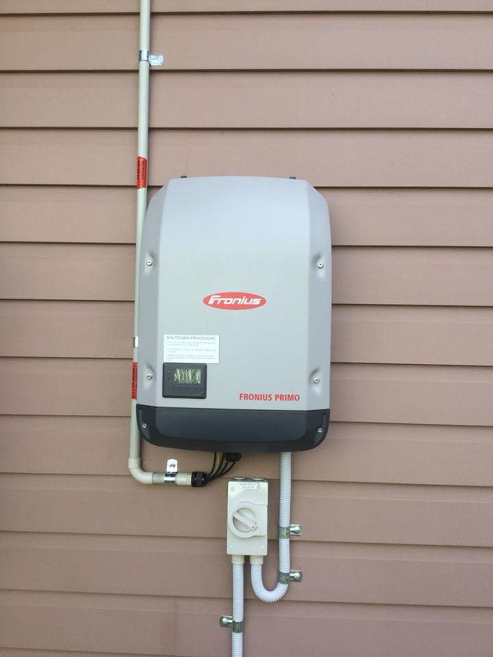 Fronius Primo solar inverter mounted on weatherboard cladding, part of a Townsville solar installation