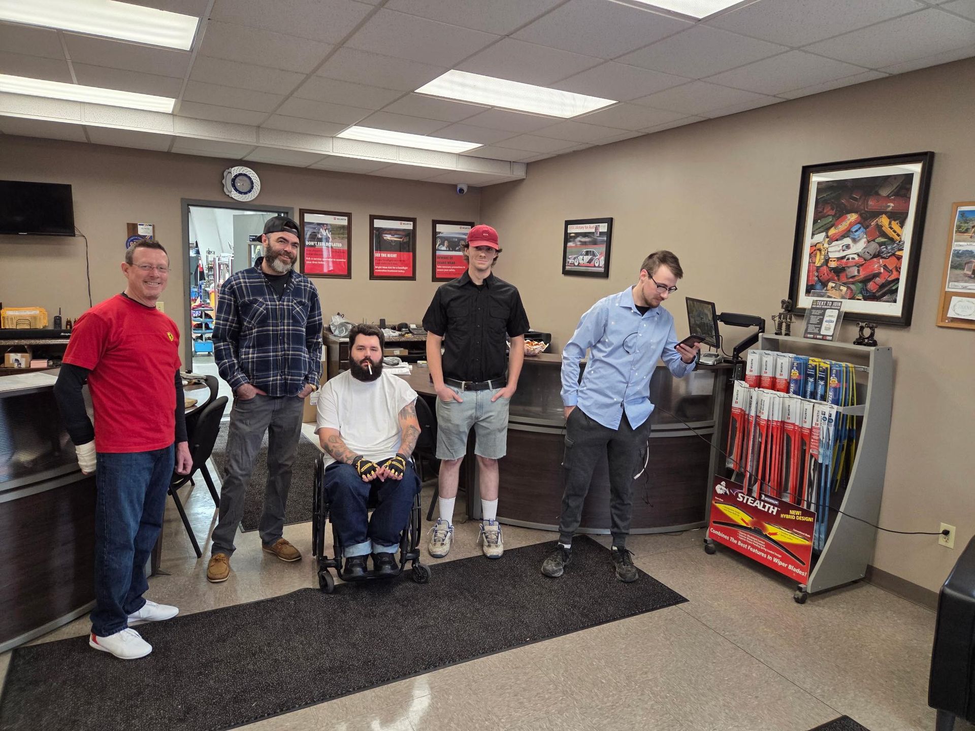 Team Standing In Neil's Motors Inc Front Office | Neil's Motors Inc