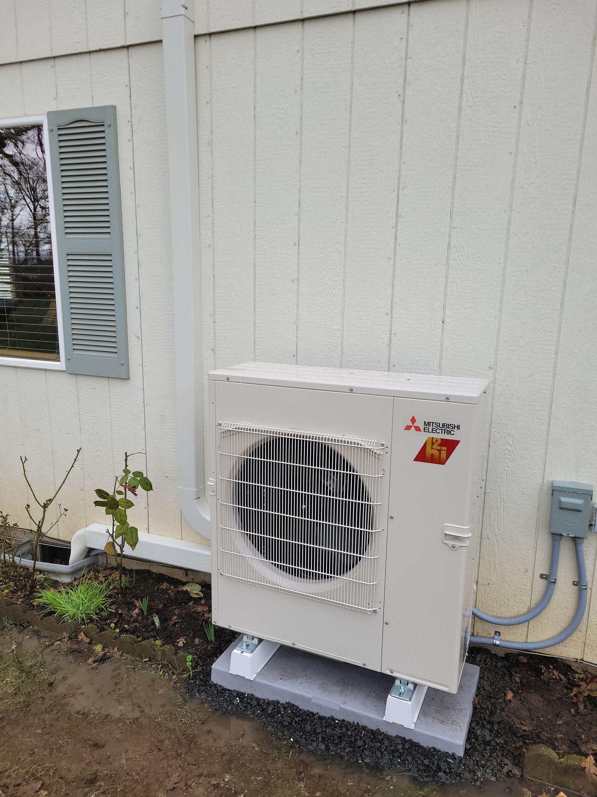 a white air conditioner is hanging on a wall in a room .
