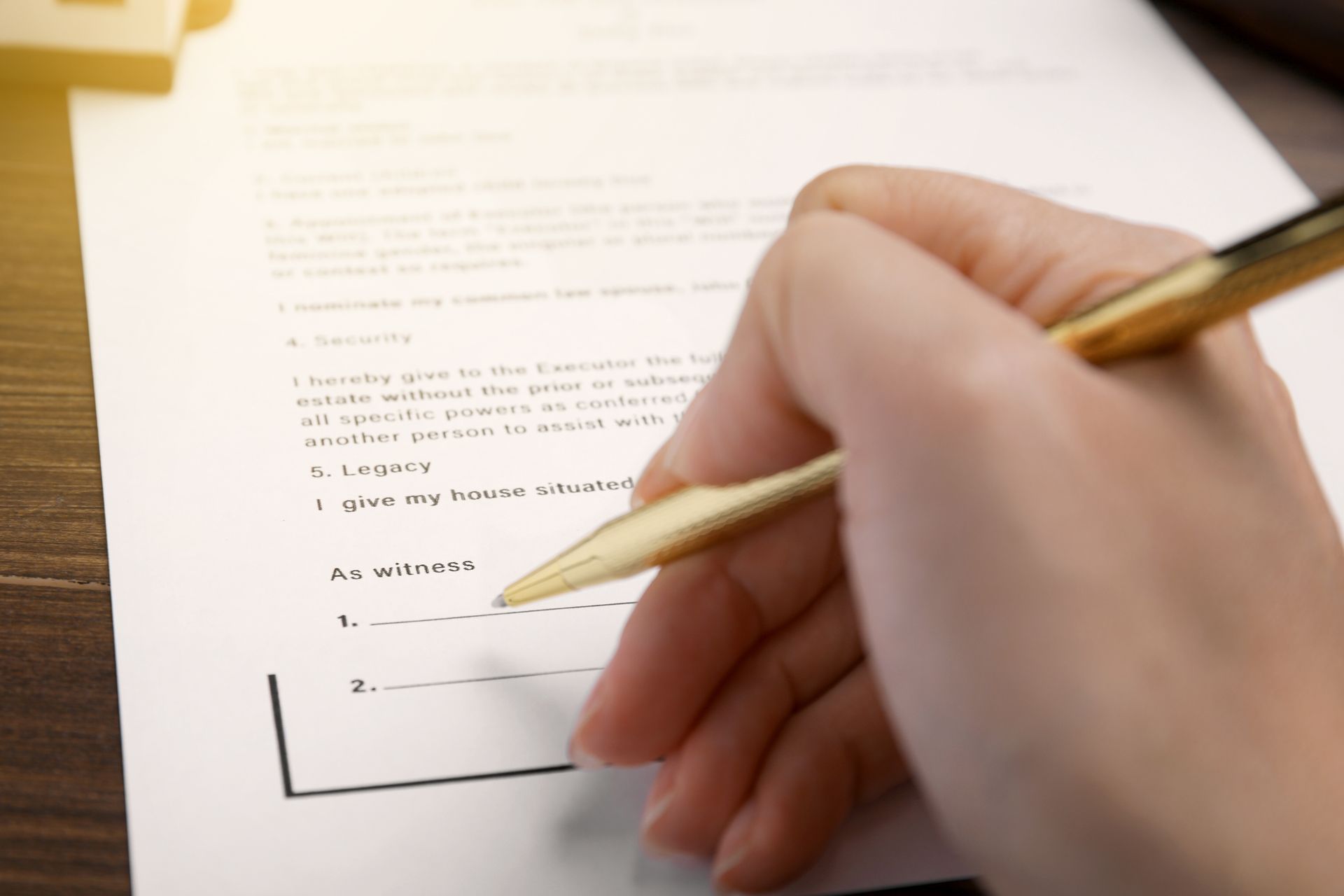 A person is writing on a piece of paper with a pen.