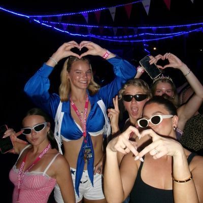 A group of women are making a heart shape with their hands
