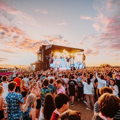 A crowd of people standing in front of a stage at a concert