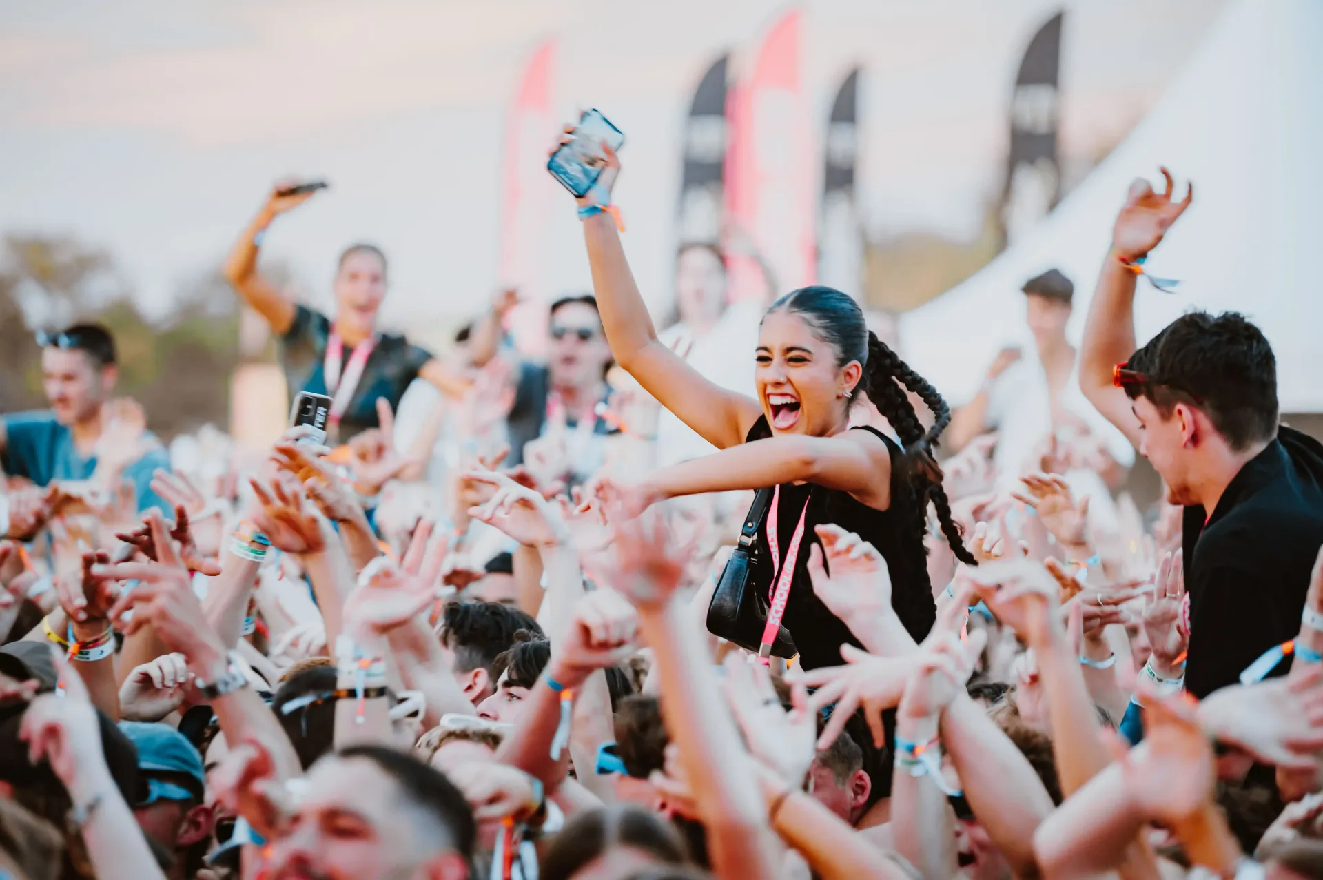 A woman is dancing in front of a crowd of people at a music festival.