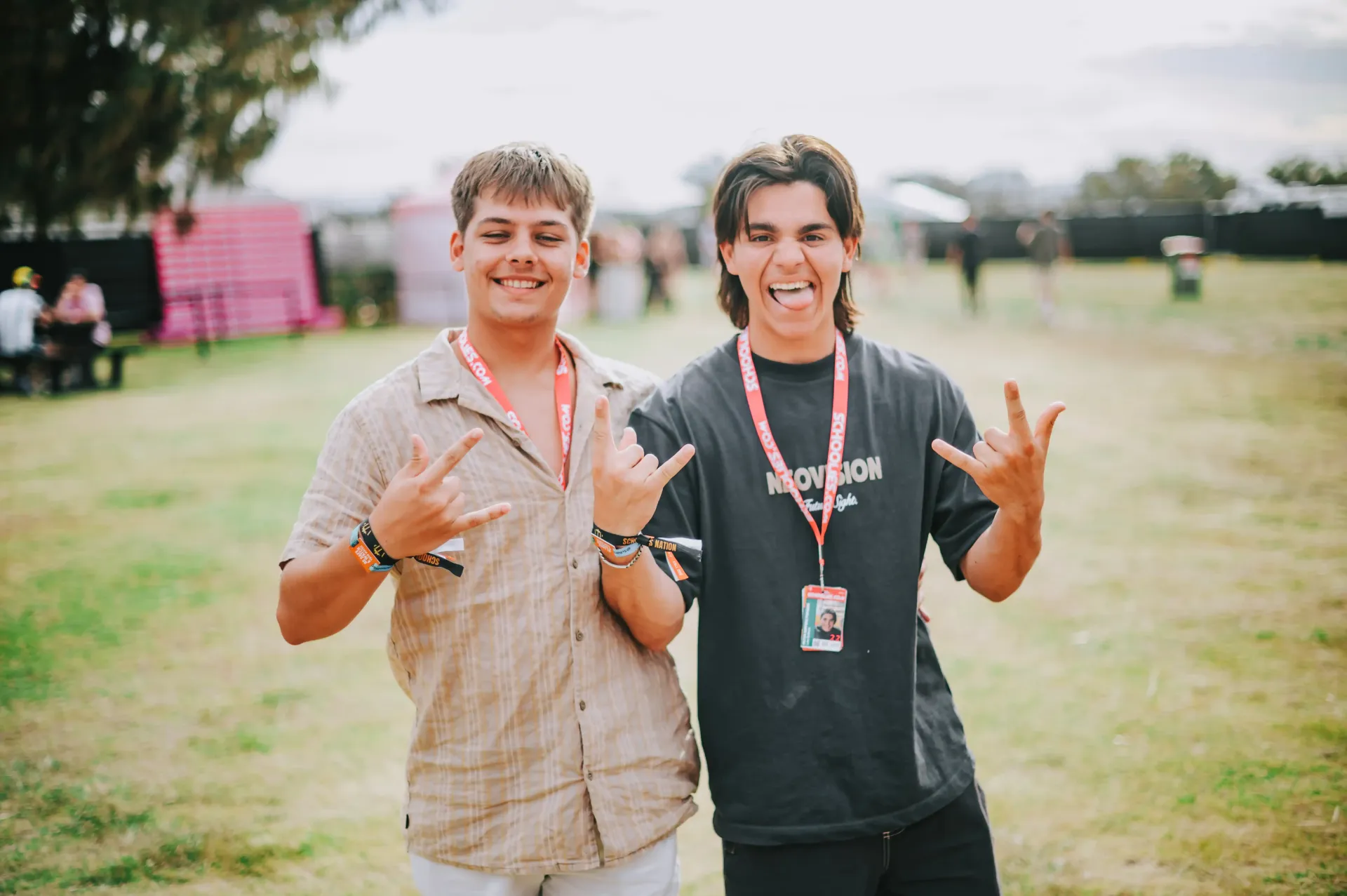 Two young men are posing for a picture in a field.