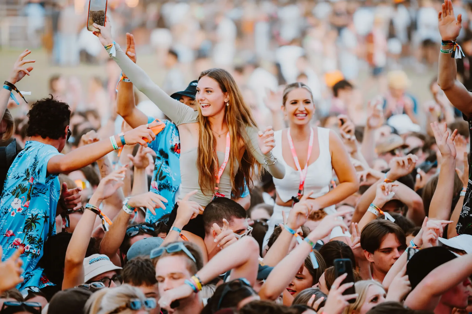 A crowd of people are dancing at a music festival.