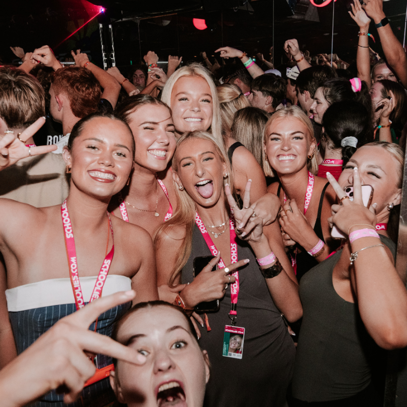 A group of people are posing for a picture and one of them has a lanyard around her neck that says bounce