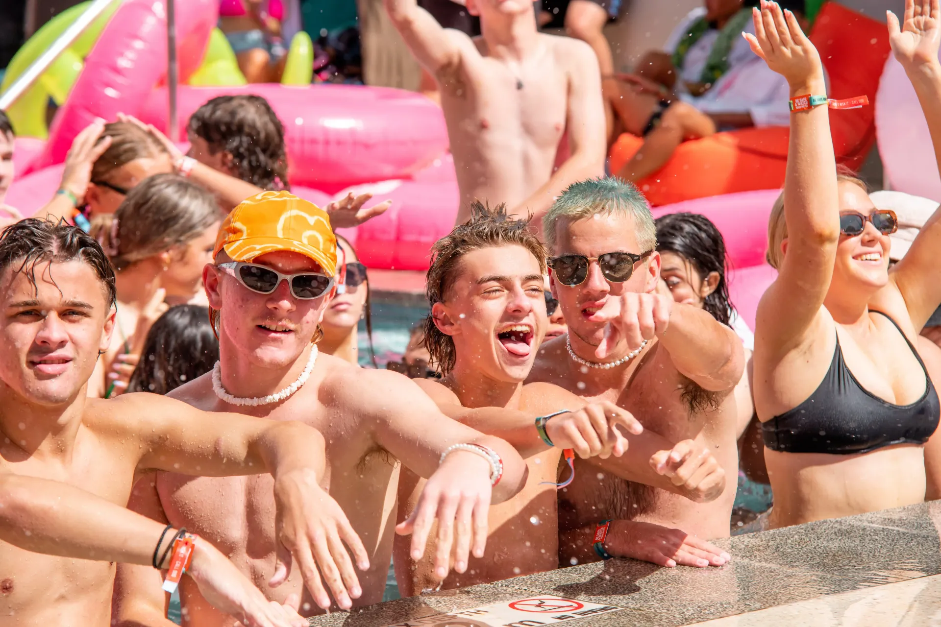 A group of people are standing in a pool with their hands in the air.