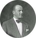 A black and white photo of a man in a suit and bow tie.