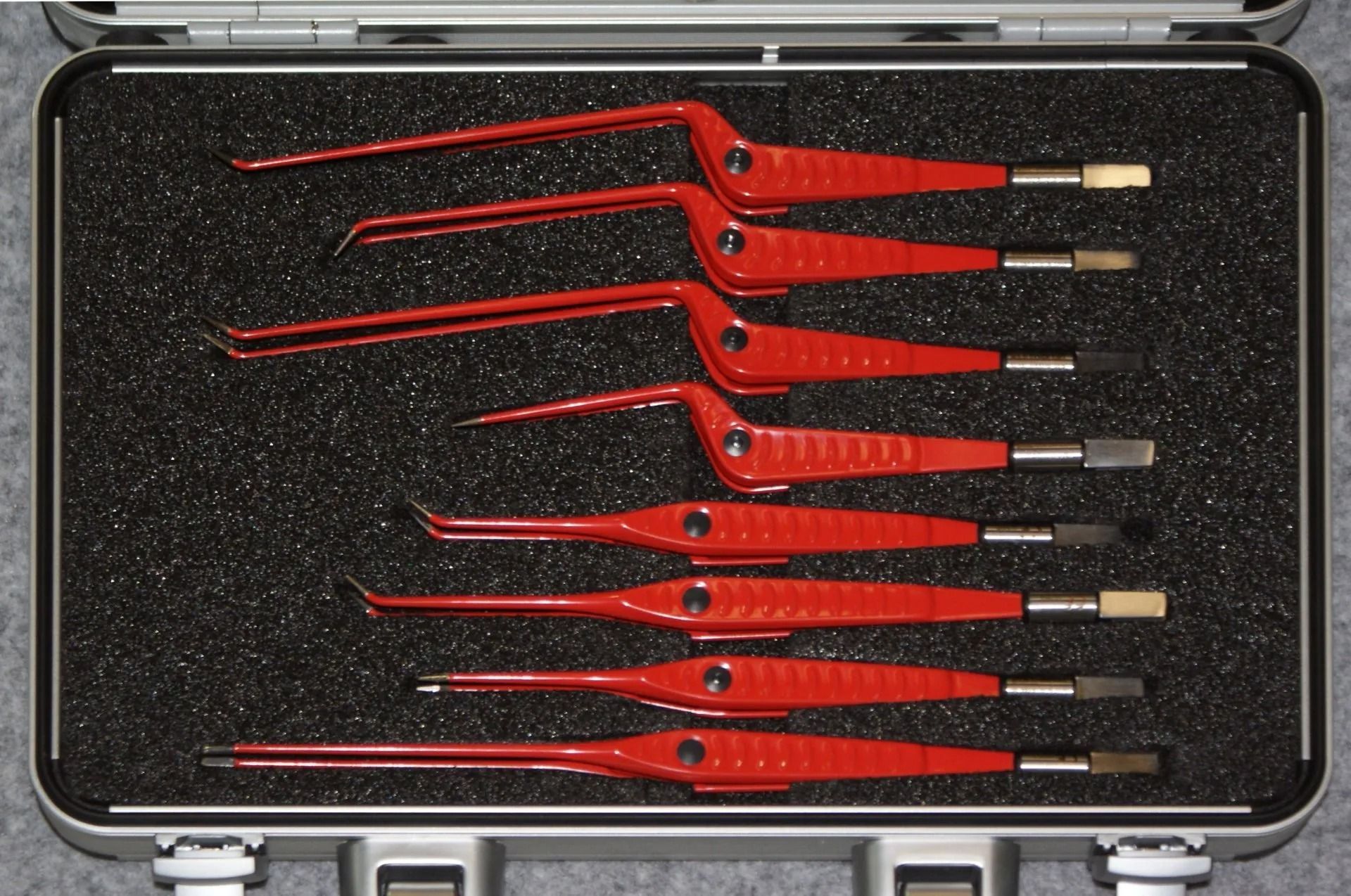 A set of red surgical instruments in a case