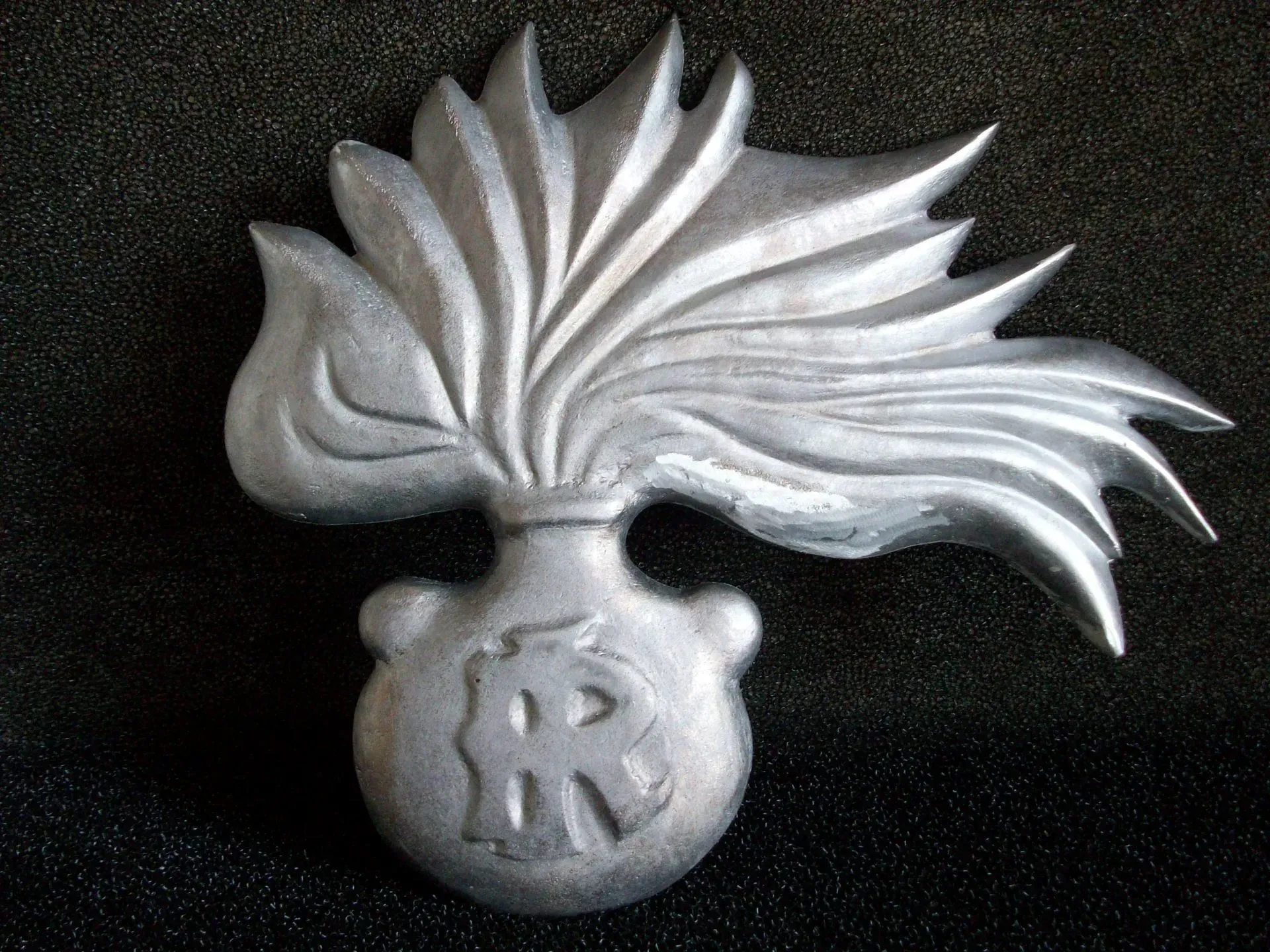Emblema di granata d'argento con fiamme e una