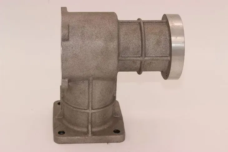Raccordo per tubi in metallo grigio angolato con base flangiata quadrata e apertura circolare.