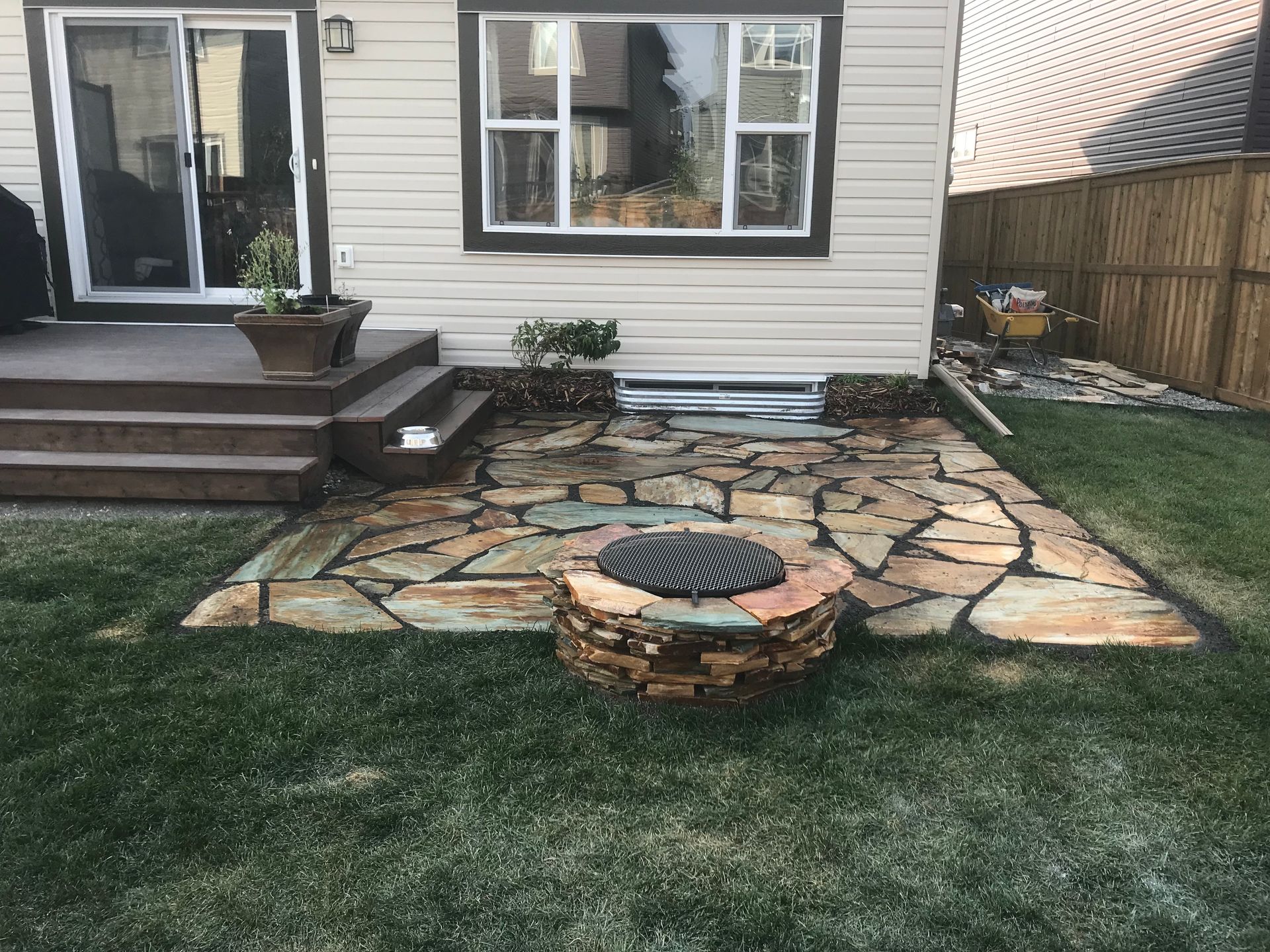 multi color stone patio and built in fire pit