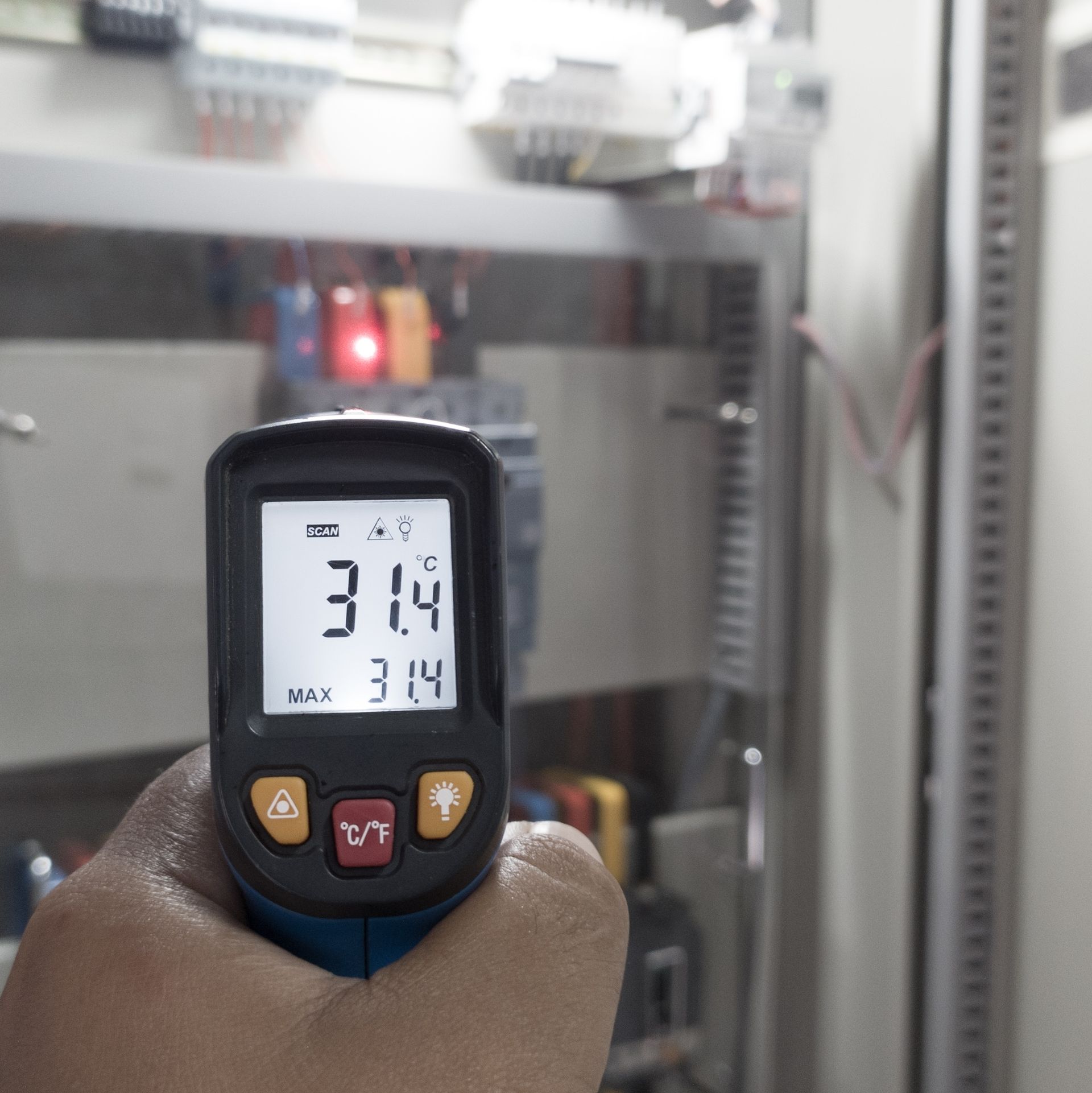 Hand holding a digital pressure gauge reading 31.4 BAR in an industrial control panel area