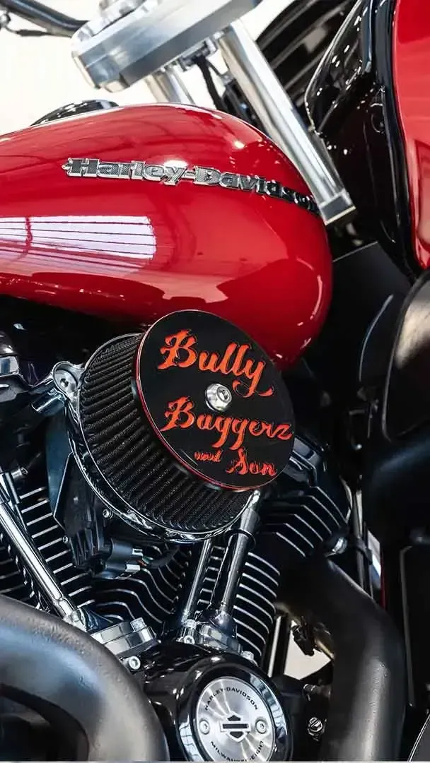 Close-up of a glossy red Harley-Davidson motorcycle engine with a black air cleaner cover labeled