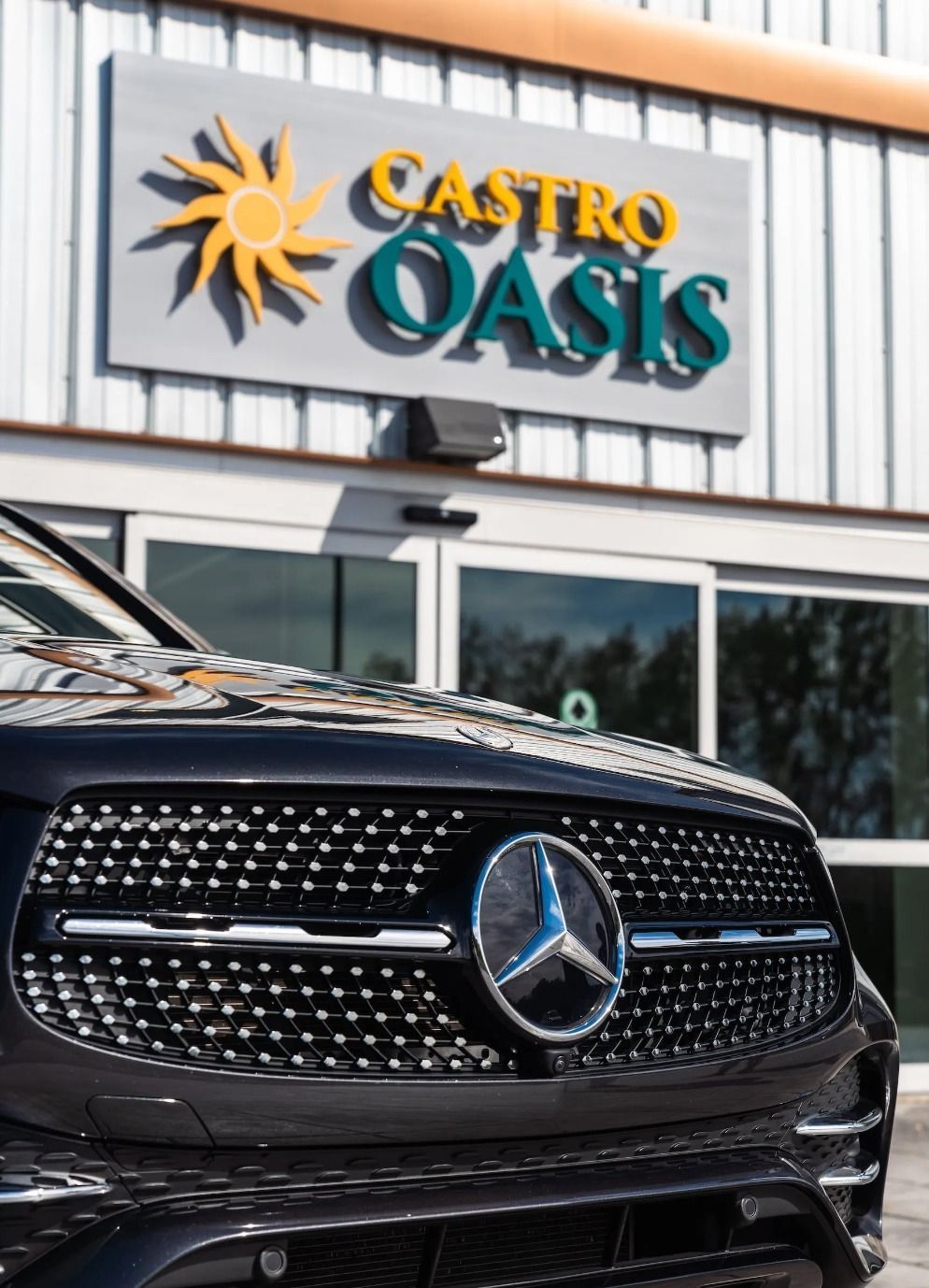 A black Mercedes-Benz front grille parked in front of a building with a