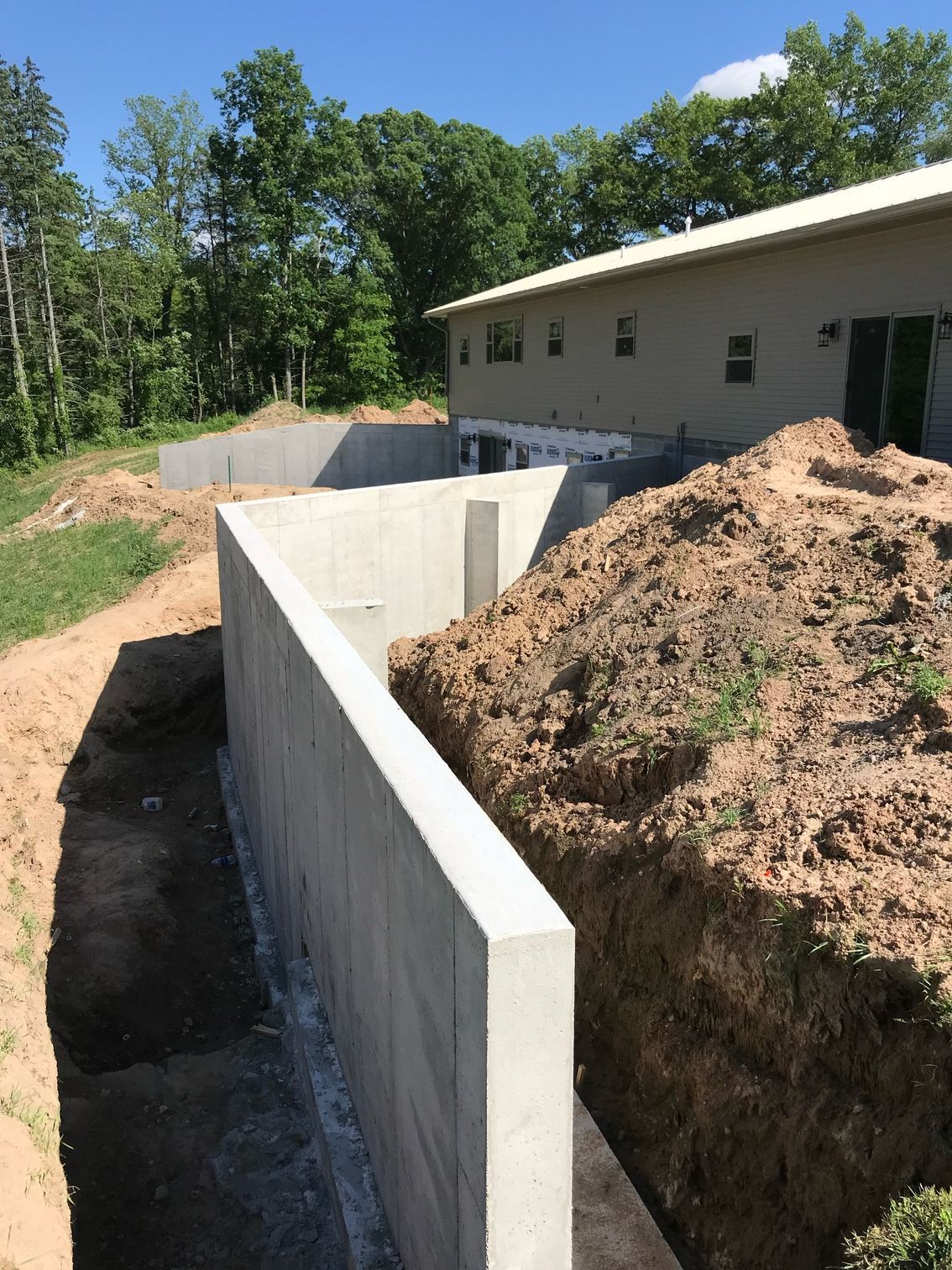 A concrete wall is being built in front of a house.