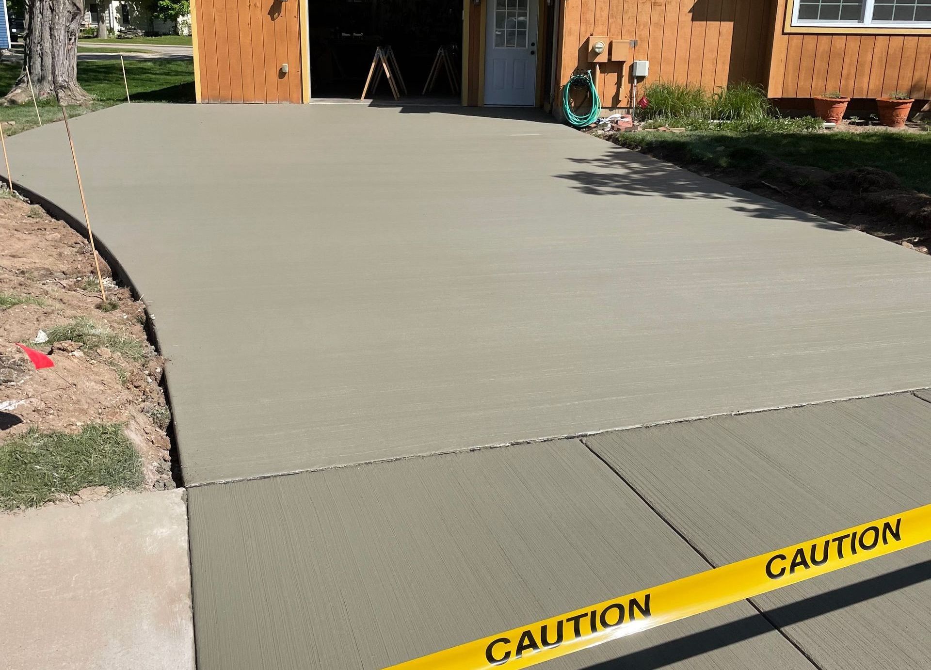 A concrete driveway with a yellow caution tape on it
